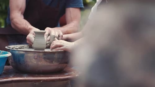 Großvater mit einem Enkel macht Krüge in Töpferei