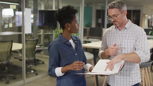 Two Colleagues Discussing Documents in Modern Office