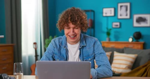 Successful Teenage Boy Sits at Table Uses Laptop Read Emails Online Home Office Gets Good