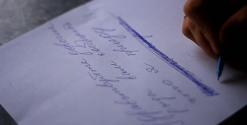 Hand Crossing Out Writing on White Paper