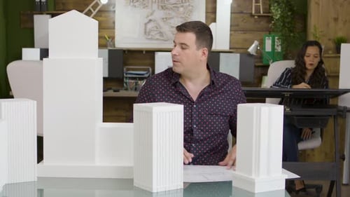 Architect Examines Building Model in Office