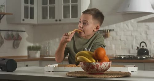 Niño comiendo solo en la cocina