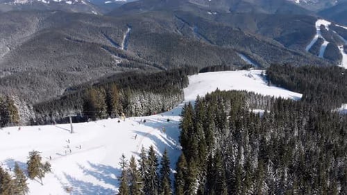 Aerial Ski Slopes with Skiers and Ski Lifts on Ski Resort. Snowy Mountain Forest