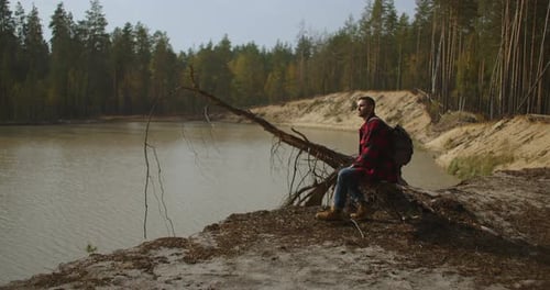 On a Walk. Hiker Walking in a Forest. Tourist Guy in Black Hoodie Wearing and Standing on Pier of