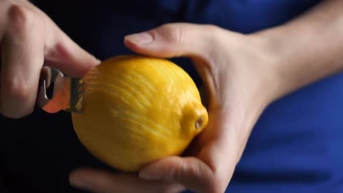 Hands Zesting a Bright Yellow Lemon