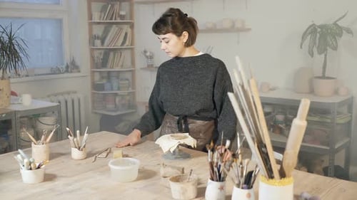 Woman Shaping Clay on Pottery Wheel in Studio