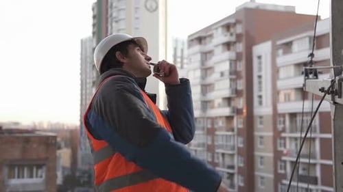 Der Vorarbeiter auf der Baustelle steuert den Prozess mit einem Walkie-Talkie.