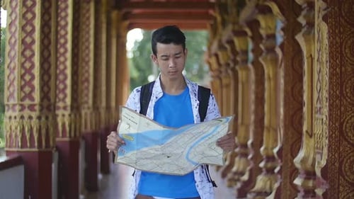 Young Tourist Using City Map at Temple