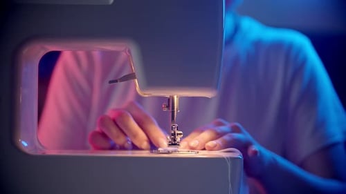 Hands Sewing Fabric with Modern Machine