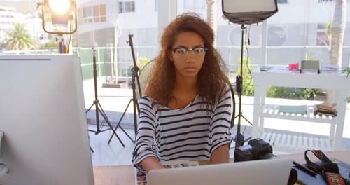 Female photographer using laptop in photo studio 4k