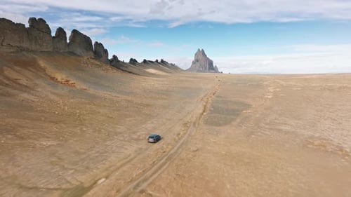 Car Driving Through Desert Landscape Aerial Shot