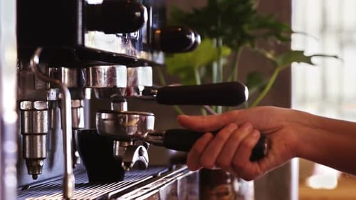 Hand inserts portafilter to make an espresso