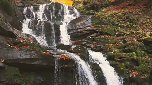 Waterfall Falling Down Mountain Slope in Autumn Forest