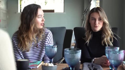 Des amies joyeuses discutant dans un café. Deux belles jeunes femmes bavardant et buvant du café