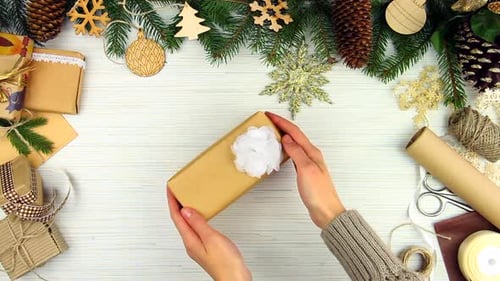 Hands Placing Decorated Gift on Festive Christmas Background
