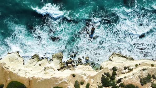 Aerial Top View Footage By Drone of Ocean Blue Waves Break on High Cliff of a Rocky Mountain