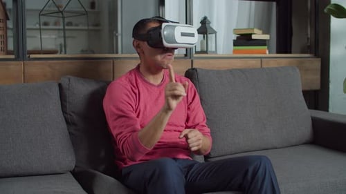 Man Uses VR Headset at Home on Couch