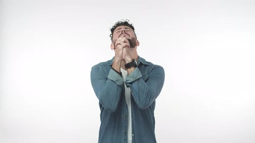 Young Man Praying in Front of White Background