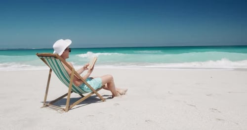 Mann liest ein Buch am Strand