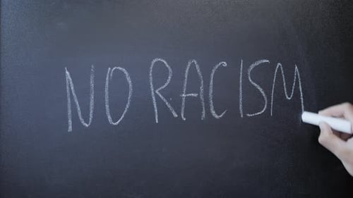 Arm Writes No Racism on Chalkboard