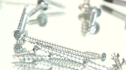 Shiny Silver Screws and Screwdriver Closeup