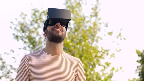 Man Experiencing Virtual Reality With Headset Outdoors