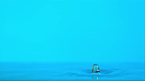 Super Slow Motion of the Water Drop Falls on the Blue Background