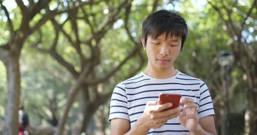 Man Using Mobile Phone in a Green Park