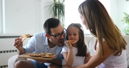 Family Eating Pizza Together on Couch