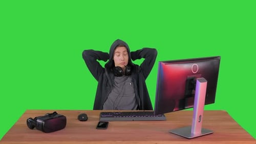 Hacker estresado y cansado sin trabajo mirando el monitor de su PC en una pantalla verde, Chroma Key.