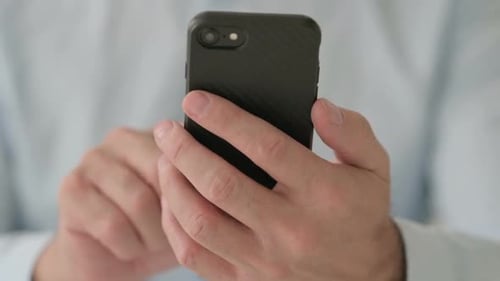 Close Up of Middle Aged Man Browsing Internet on Smartphone