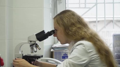 Researcher Using Microscope in Clinical Laboratory