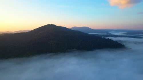 4K Scenic flight over beautiful mountain scape with bright sky and clouds
