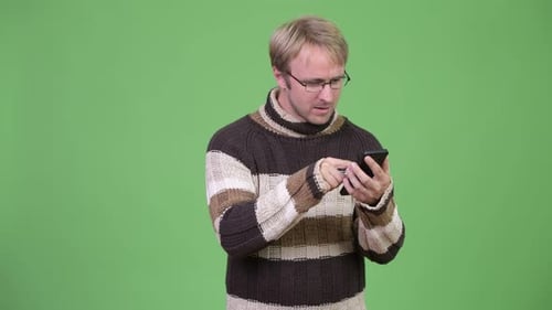Studio Shot of Stressed Man Using Phone and Getting Bad News