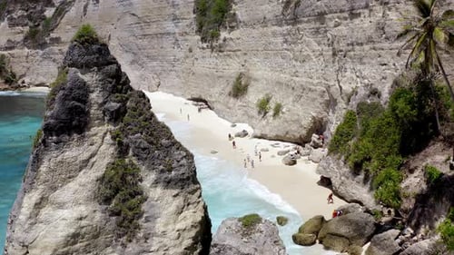 Diamond Beach in Nusa Penida island Indonesia with bathers enjoying the turquoise colored ocean wate
