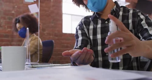 Person Sanitizing Hands at Work During Day