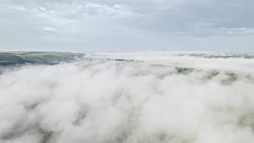 Aerial Drone View on Village or City in Valley Between Mountains During Misty Morning