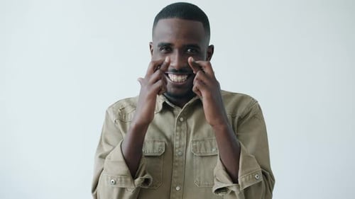 Portrait of Joyful African American Man Crossing Fingers Makign Wish on White Background