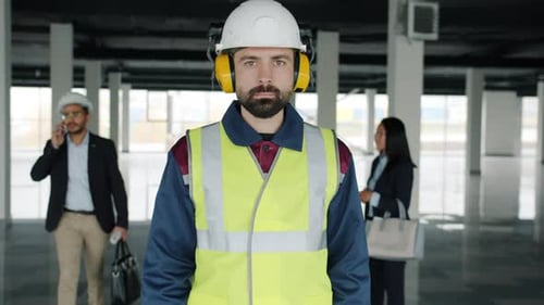 Portrait of Construction Specialist Wearing Safety Uniform Standing in Empty Building with