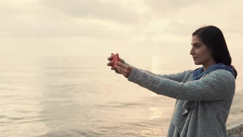Woman Is Trying To Take Selfie with Sunset By Her Smartphone,standing Near Sea