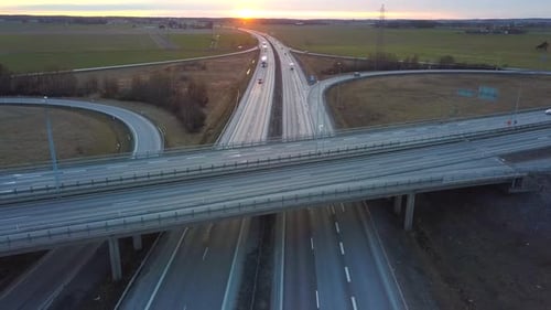 Aerial view of freeway intersection with moving traffic cars.