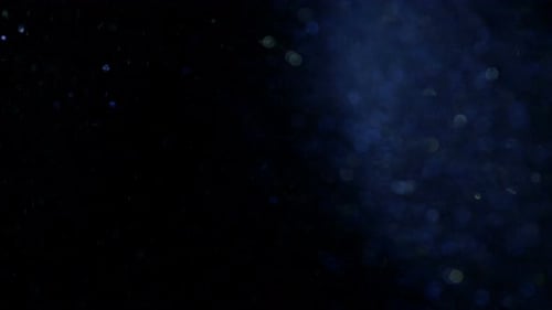 Sparkling Glitter Particles Floating on Dark Background