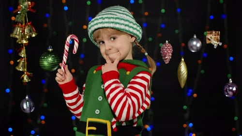 Happy Girl Dressed as Christmas Elf with Candy Cane