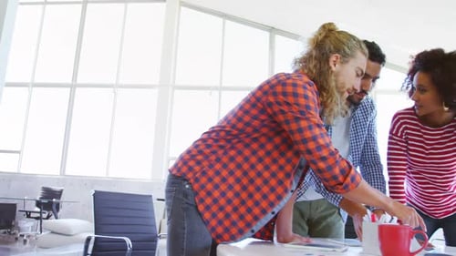 Des collègues discutent autour de documents à la table 4k