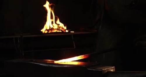 Blacksmith Shaping Hot Metal on Anvil with Hammer