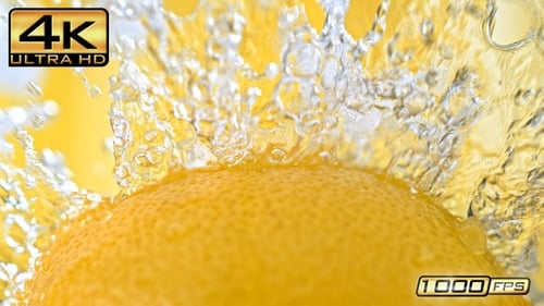 Fresh Lemon Splashed with Water on Yellow Background