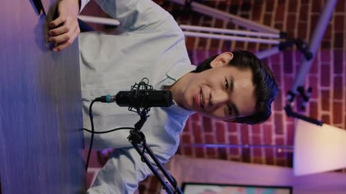 Young Man Podcasting into Microphone in Studio Setting