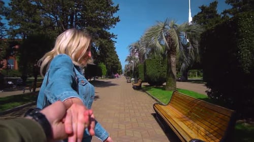 fille approche mec, prend sa main et ils courent au Ralenti à travers la ville