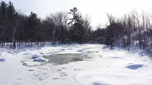 stream running through forest covered in snow low flight beauty.