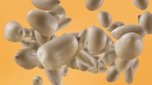 Peanuts Falling in Slow Motion on Orange Background